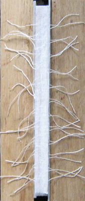 A layer of scrim covers the  threads.